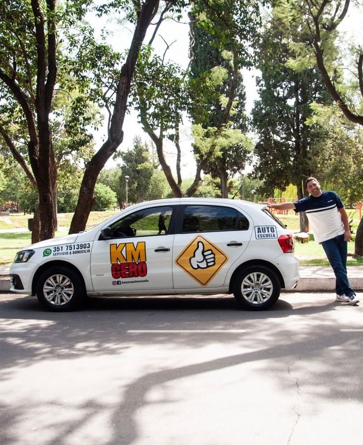 Instructor de Km Cero Auto Escuela junto al auto de la escuela de manejo
